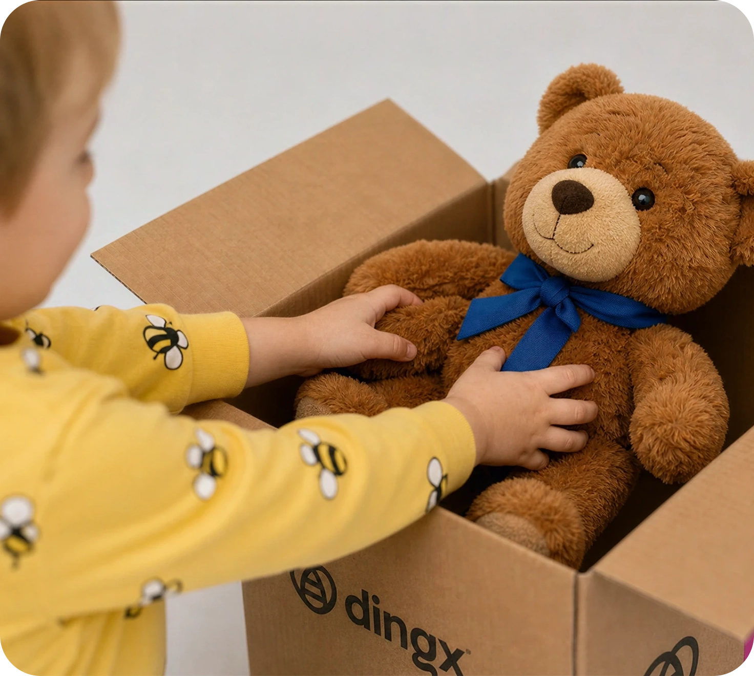 Ein dingx-Kurier übergibt einer Kundin eine pinke dingx-Box neben einem Lieferroboter
